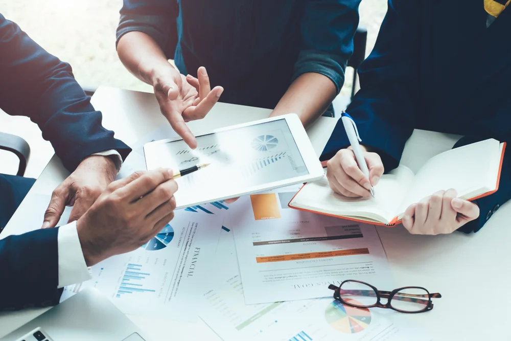 Two business people shaking hands over a desk