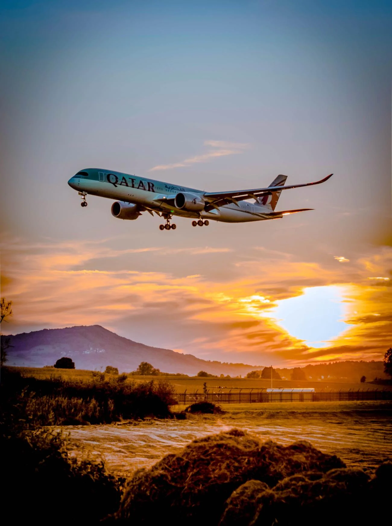 A passenger aircraft taking off against a sunset sky